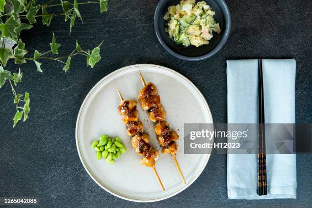 yakitori de pollo japonés casero, frijoles edamame, ensalada de patata japonesa, sobre fondo oscuro con palillos - pinchito fotografías e imágenes de stock