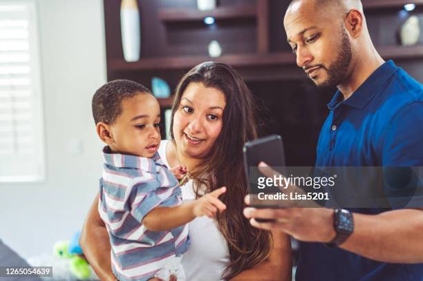 mixed race family with one child takes a selfie indoors - uncle nephew stock pictures, royalty-free photos & images