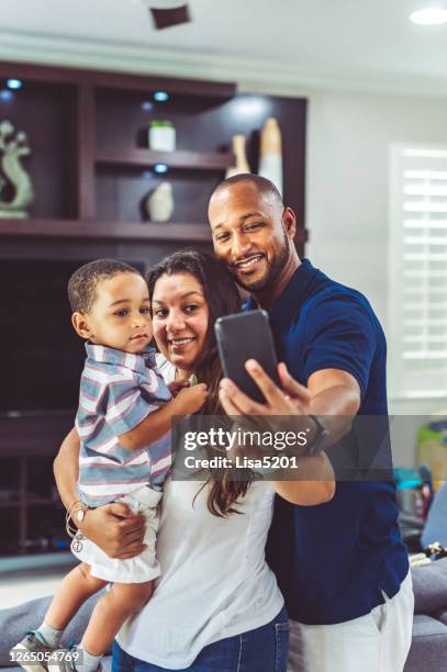 gemischte rennfamilie mit einem kind macht ein selfie drinnen - aunt stock-fotos und bilder