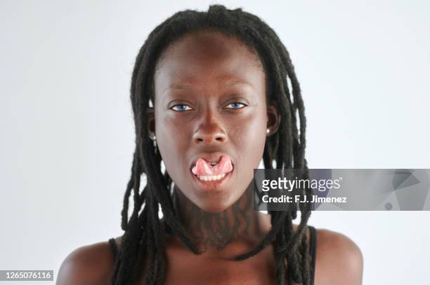 portrait of woman sticking out her forked tongue - gespleten tong stockfoto's en -beelden