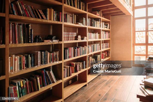 houten boekenplanken die met boeken worden gevuld - boekenkast stockfoto's en -beelden