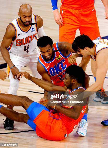 Hamidou Diallo and Terrance Ferguson of the Oklahoma City Thunder fight for a loose ball against Jevon Carter and Dario Saric of the Phoenix Suns...