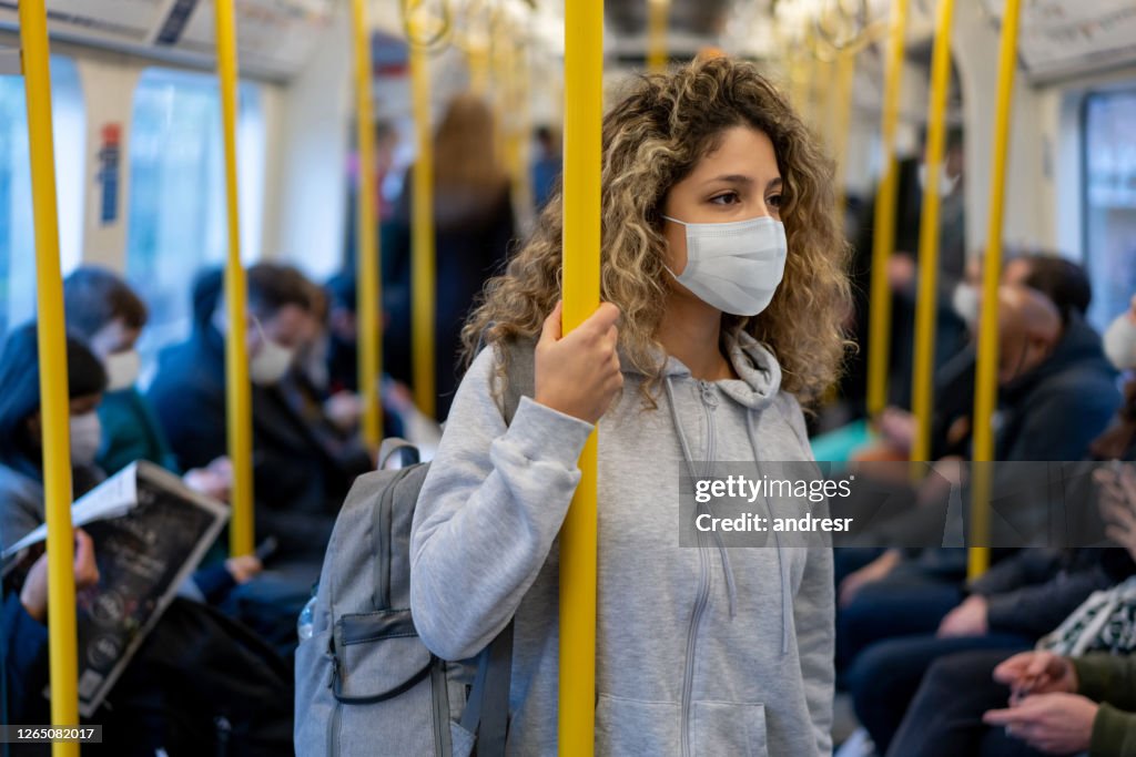 Woman riding on the metro wearing a facemask to avoid an infectious disease