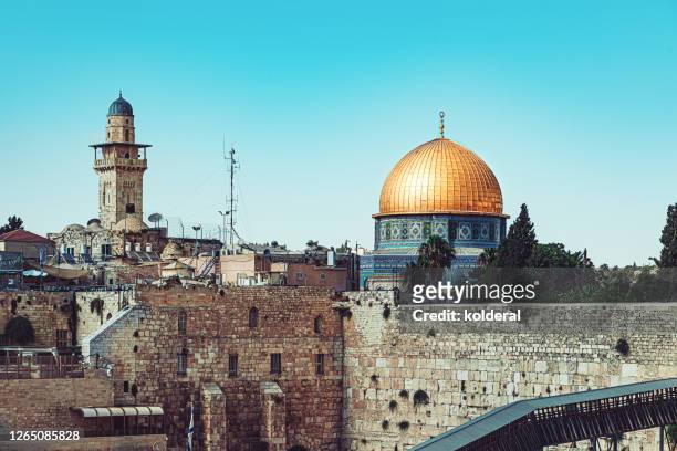 western wall with golden dome of the rock mosque against blue sky - historical geopolitical location fotografías e imágenes de stock