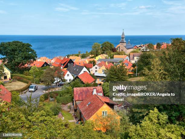 village view gudhjem, view over the roofs and the church to the baltic sea with christiansoe, christiansoe on the horizon, gudhjem, bornholm, denmark - bornholm stock pictures, royalty-free photos & images