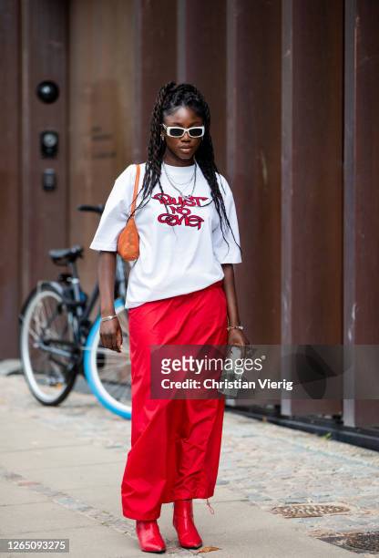 Guest is seen wearing red skirt, white shirt with print outside 7 days active during Copenhagen Fashion Week SS21 on August 10, 2020 in Copenhagen,...