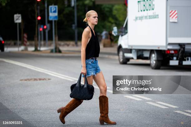 Guest is seen wearing denim jeans, brown boots outside 7 days active during Copenhagen Fashion Week SS21 on August 10, 2020 in Copenhagen, Denmark.