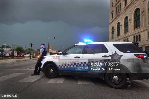 Police officer stands guard following unrest on the city's westside moments before a derecho storm hits the area on August 10, 2020 in Chicago,...