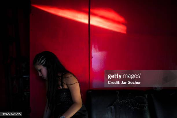 Salvadoran sex worker sits in front of a room where her sexual services are offered to clients on November 19, 2016 in San Salvador, El Salvador....
