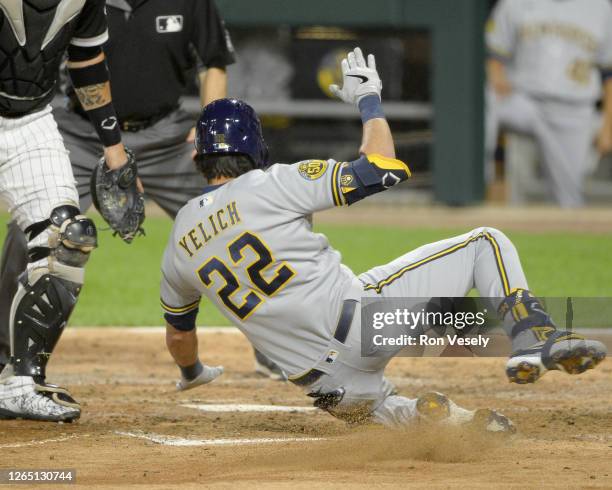Christian Yelich of the Milwaukee Brewers slides home safely after hitting an inside-the-park home run against the Chicago White Sox on August 6,...