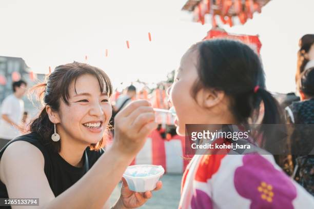 moeder en dochter die van de zomerfestival genieten - shaved ice stockfoto's en -beelden