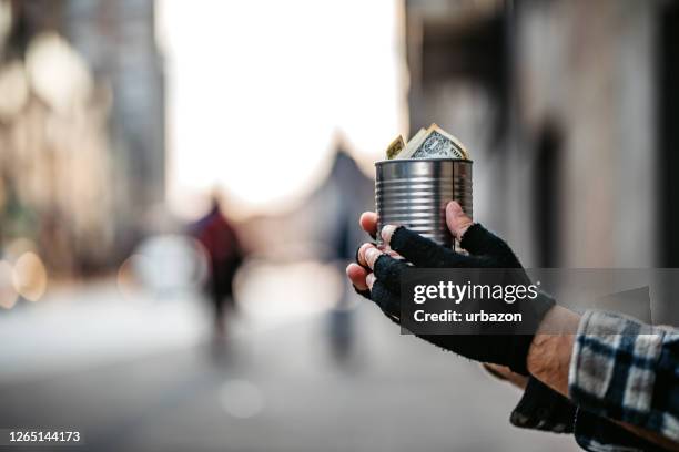 bedelaar die een blikje voor geld houdt - blank can stockfoto's en -beelden