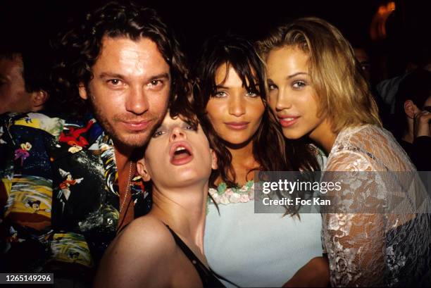 Michael Hutchence, Kristen McMenamy, Helena Christensen, and Emma Sjoberg attend a Yves Saint Laurent Show during A Paris Fashion Weeks in the 1990s...