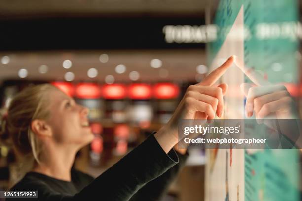 verwenden des touchscreens am flughafen - berührungsbildschirm stock-fotos und bilder