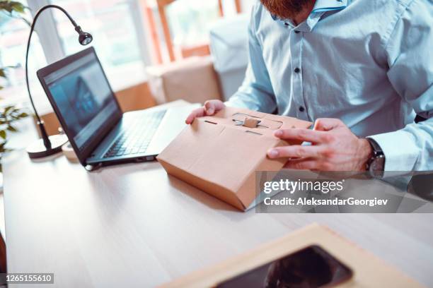 male office worker folding a cardboard package - packaging design stock pictures, royalty-free photos & images