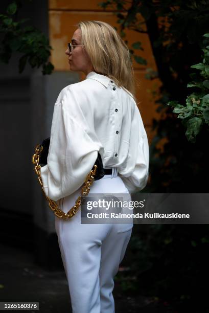 Sandra Hagelstam outside Designers Remix wearing white shirts with buttons on the back, white pans and black Bottega Veneta bag during Copenhagen...