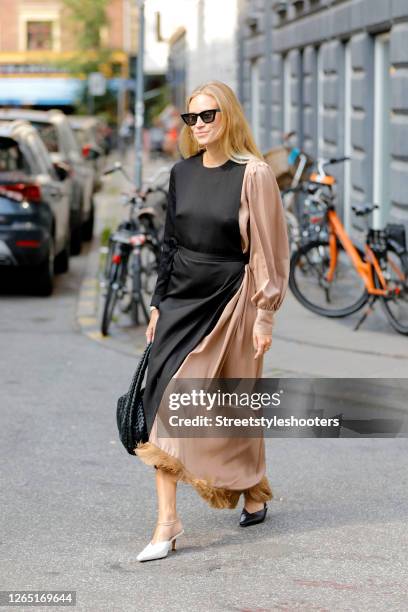 Influencer Tine Andrea, wearing a black apricot bicolored dress a black bag by Bottega Veneta and one black and one white shoe seen at Copenhagen...