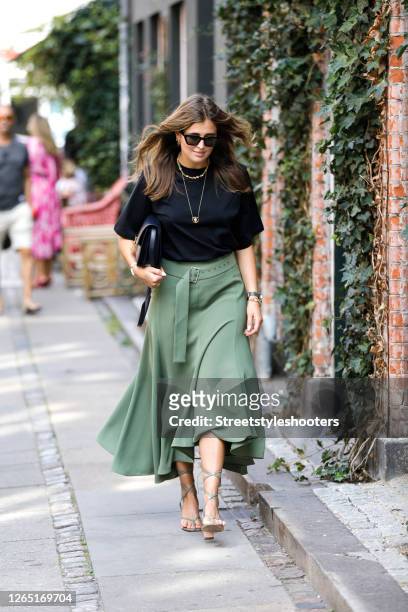Influencer Darja Barannik, wearing a black shirt, a long green skirt, a black bag and green sandas by Bottega Veneta seen at Copenhagen Fashion Week...
