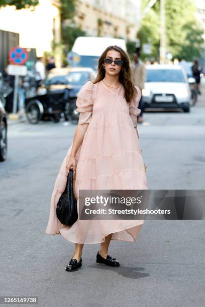 Influencer Sarah Lou Falk, wearing a rose colored dress by Brigitte Herskind, a black Vintage bag by Bottega Veneta, black loafers by Scarosso and...