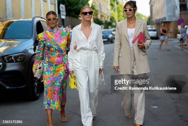 Janka Polliani wearing colorful dress and Tine Andrea wearing white pants, white silk shirt, yellow bag and Darja Barannik wearing beige suit, pink...