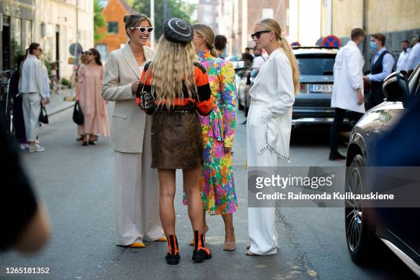 Darja Barannik wearing beige suit, pink bag and Janka Polliani wearing colorful dress and Tine Andrea wearing white pants, white silk shirt, yellow...