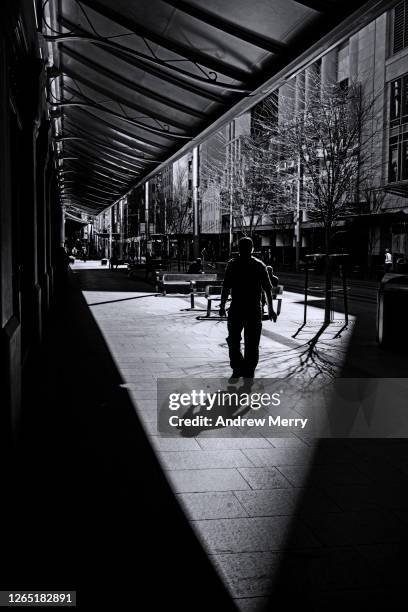 silhouette of man walking on empty city street - psychiatric ward stock pictures, royalty-free photos & images