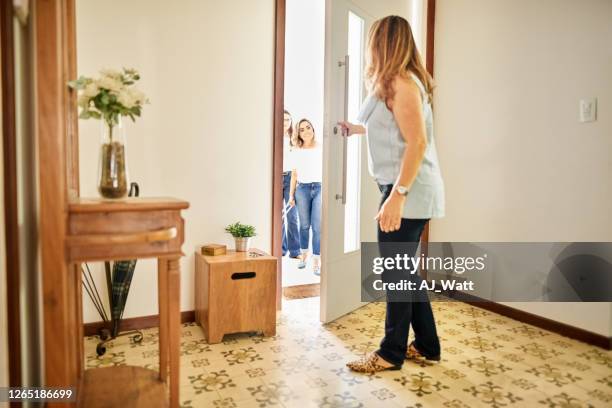 opening the door to receive her friends - guest room stock pictures, royalty-free photos & images