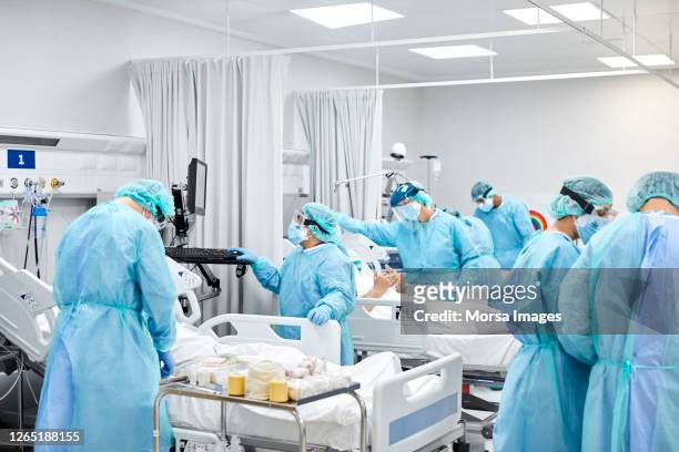 healthcare coworkers working in icu during covid-19 - state of emergency stock pictures, royalty-free photos & images
