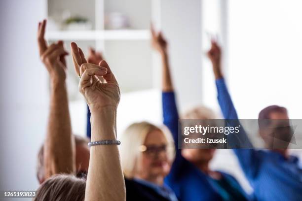 people voting during meeting in nursing home - votação imagens e fotografias de stock