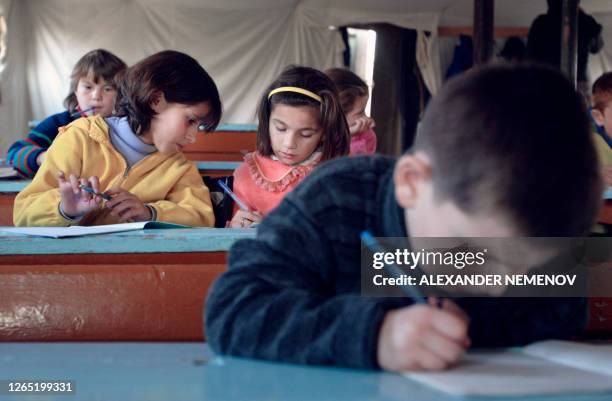 Chechen pupils have their lessons in a school tent of "Sputnik" refugee camp in Ingush town of Karabulak some 20 kms from Chechen border, 22 November...