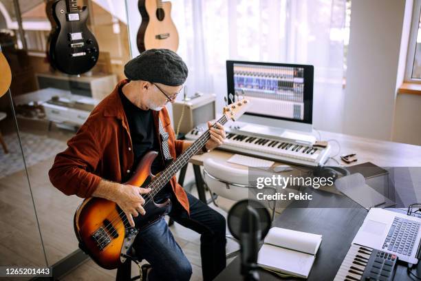senior rock gitarrist spielt gitarre in seinem heimstudio - bassgitarre stock-fotos und bilder