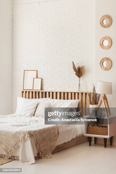 light and spacious bedroom with white wall and eco diy wooden furniture. cozy bright bedroom in rustic style. - beige bedroom stock pictures, royalty-free photos & images