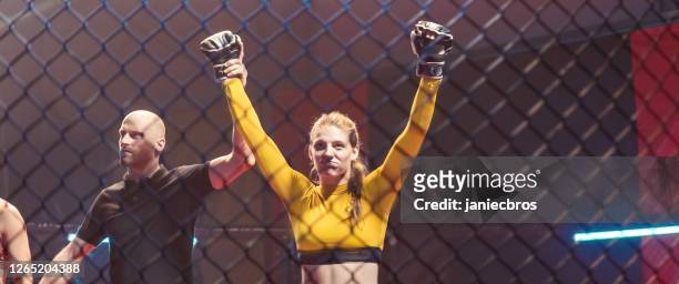 referee declairing the winner after the mma female fight. inside octagon - mma ring stock pictures, royalty-free photos & images