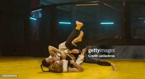 mma formation de combat féminin. partenaire de lancement sur le tapis - jiu jitsu photos et images de collection