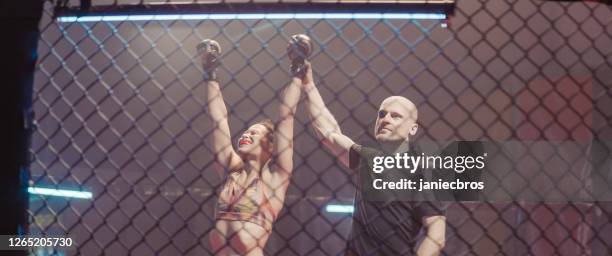 referee declairing the winner after the mma female fight. inside octagon - mixed martial arts stock pictures, royalty-free photos & images