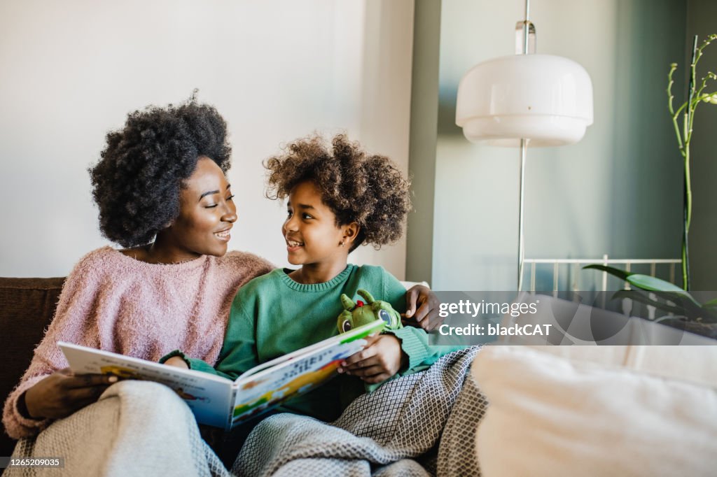 De jonge moeder leest een boek aan haar dochter