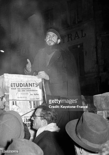 Abbe PIERRE giving a conference before homeless people, notably students, in Paris in January 1954.