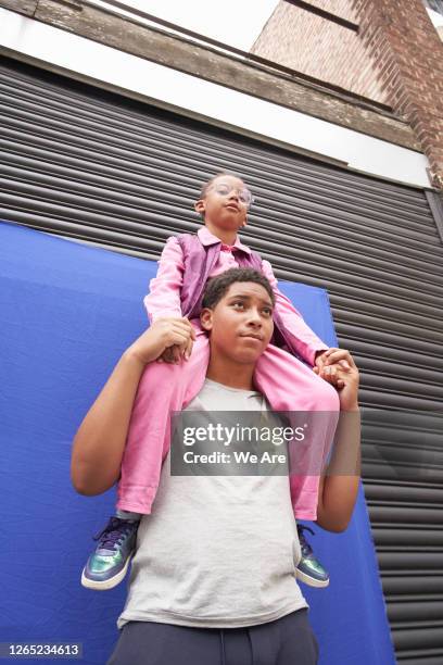 big brother shoulder ride - family on coloured background stock pictures, royalty-free photos & images