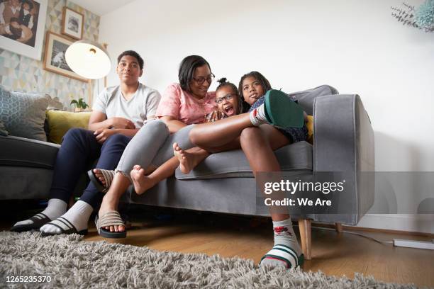 cheerful family relaxing on sofa - family in front of tv stock pictures, royalty-free photos & images