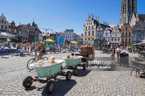 Vespaqua, Vespa Ape pulling bathtubs on wheels with happy little children having fun at the Grand Place of Mechelen / Malines, Flanders, Belgium.
