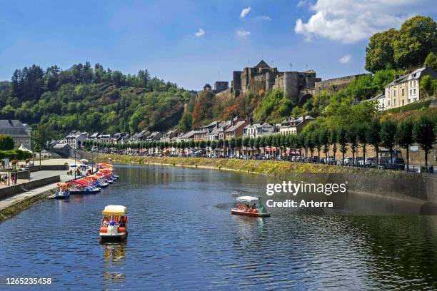 Paddle boats with tourists on the Semois river in front of Chateau de Bouillon Castle in summer, Luxembourg Province, Belgian Ardennes, Belgium.