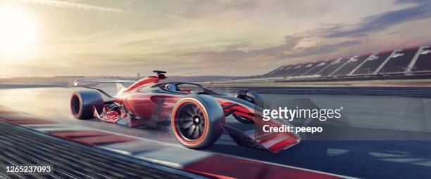 racing car moving at speed on race track at sunset - grand prix motor racing stock pictures, royalty-free photos & images