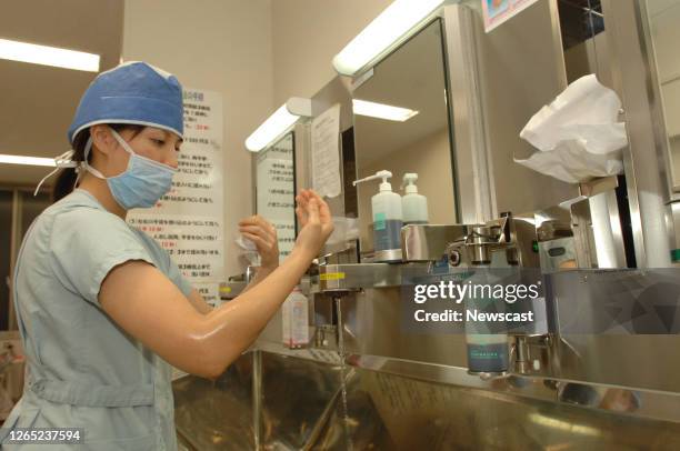 Nurse scrubbing up prior to consulting with a patient, Japanese Red Cross Hospital, Kyoto, Japan.