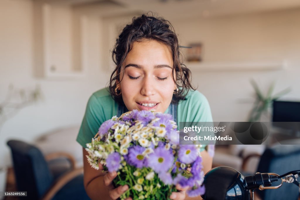 Porträt einer schönen Frau, die den Geruch von frischen Blumen genießt