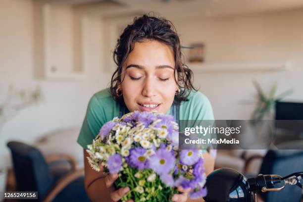 verticale d’une belle femme appréciant l’odeur des fleurs fraîches - odorat photos et images de collection