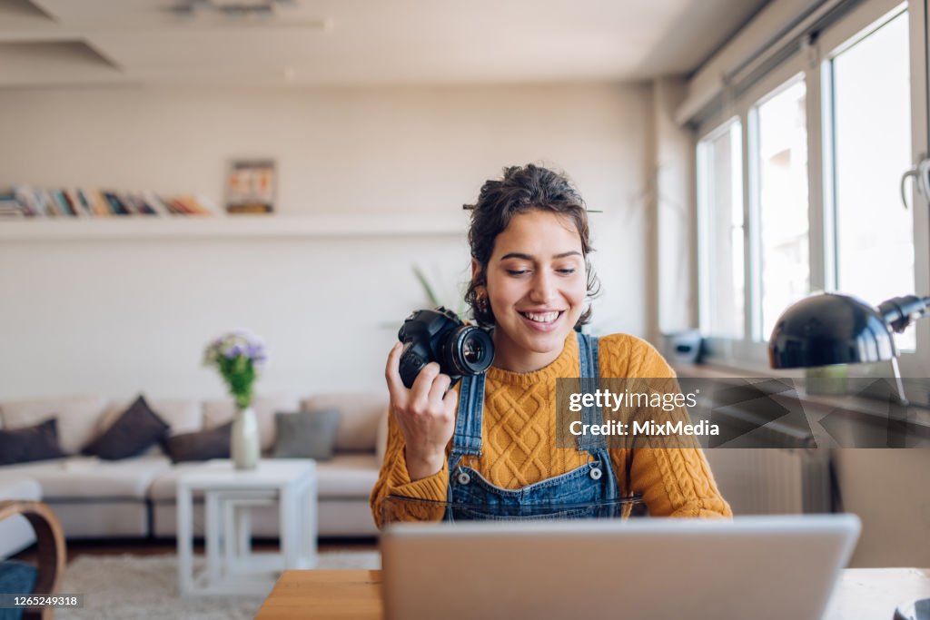 Young photographer working on her photos at her home office