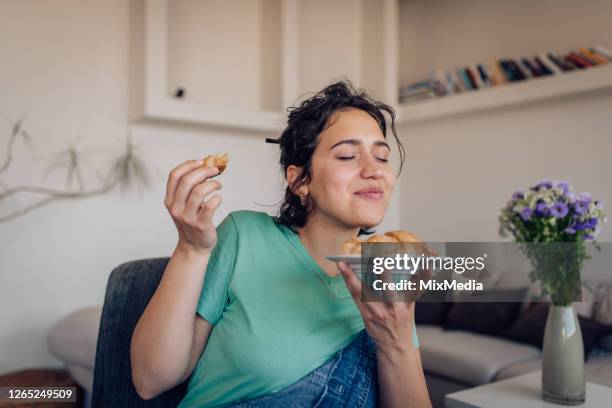 beautiful girl enjoying the taste of a fresh croissant - croissant stock pictures, royalty-free photos & images