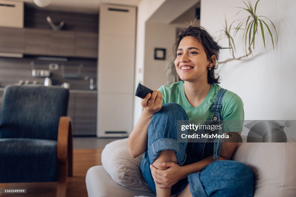 Ragazza che si gode il suo programma TV preferito a casa