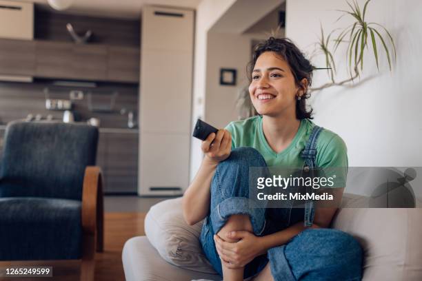girl enjoying her favorite tv show at home - television show imagens e fotografias de stock
