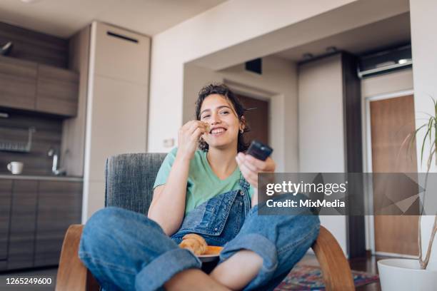 happy girl watching tv in the morning and having breakfast - snacks stock pictures, royalty-free photos & images